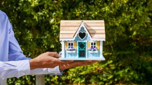 real estate agent holding a cute dollhouse